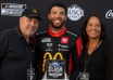 Bubba Wallace with his parents, Darrell Wallace Sr. and Desiree Wallace, celebrating together at a NASCAR event.