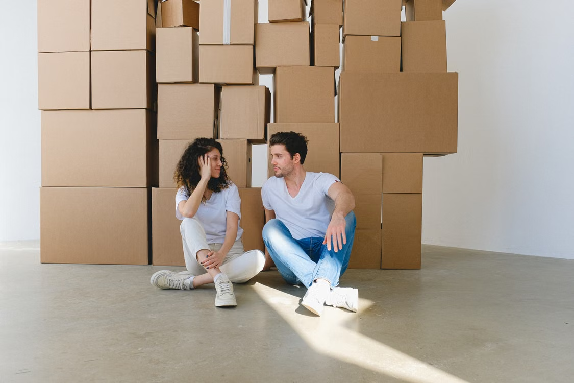 Couple preparing mentally for a move from the USA to Poland with packed boxes