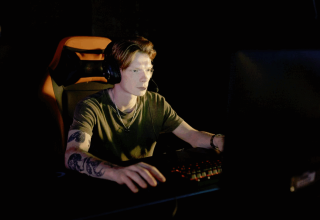 Gamer wearing a headset playing at a desktop computer