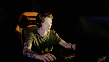 Gamer wearing a headset playing at a desktop computer