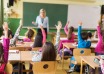 Children raising their hands during a classroom lesson