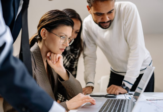 Colleagues reviewing information together on a laptop