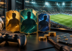 Football player cards, a game controller and gold tokens beside a stadium pitch