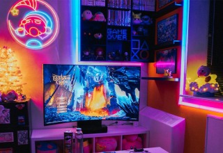 Gaming room with a television, neon wall sign and colorful RGB strip lighting