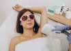 Woman wearing protective goggles during underarm hair-removal treatment