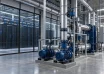 Cooling pipes and circulation pumps beside data center server racks