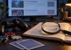 Game controller, poker chips and a magnifying glass over review notes on a desk.
