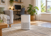 Portable air purifier in a bright living room with a home computer desk